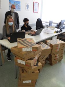 Lina Faller und Beytullah Baylan nehmen zusammen mit Konrektor Mirko Buhl mit neuen Laptops